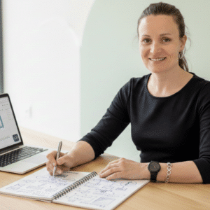 Natalia de LocalGrow trabajando en un Sprint Estratégico para emprendedores. Se ve un portátil con el logo de LocalGrow, gráficos de negocio y un cuaderno con anotaciones tácticas. Ambiente profesional y resolutivo