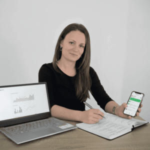 Natalia de LocalGrow realizando una Auditoría Mystery 360. Se la ve analizando un proceso de venta en el móvil, con el portátil abierto mostrando gráficas de rendimiento y tomando notas estratégicas en su Documento Maestro. Actitud de experta analizando la experiencia de cliente.